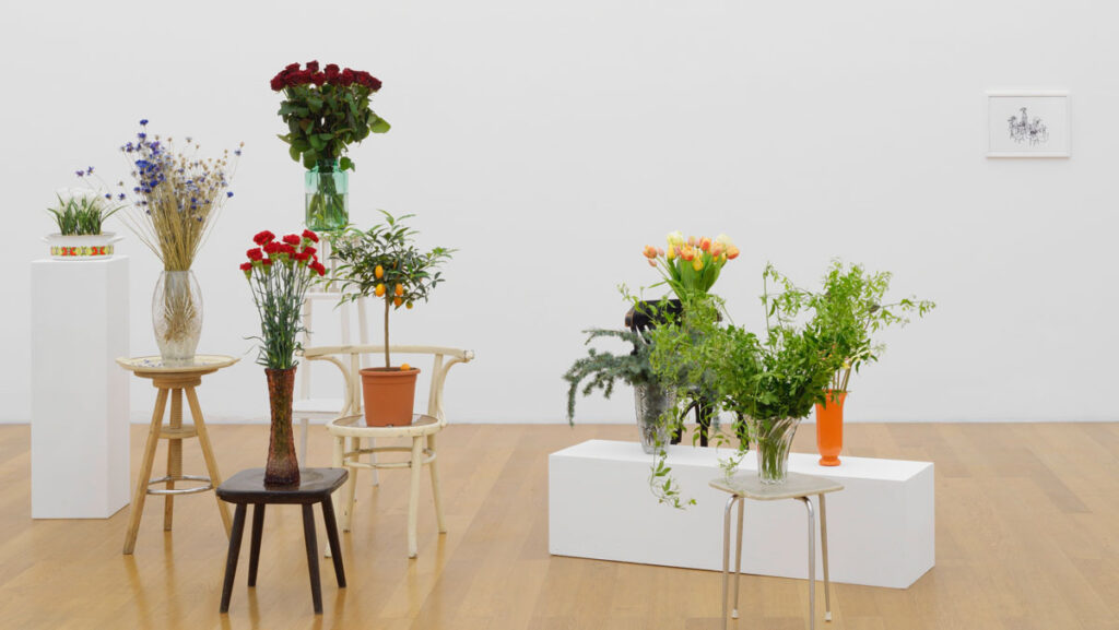 Anna Jermolaewa, The Penultimate, 2017, Wood, glass, metal, plastic; drawing (felt-tip pen on paper); vase with fresh flowers, dimensions variable. Installation view Parliament of Plants, Kunstmuseum Liechtenstein, 6.9.2020 – 17.1.2021. Photo: Stefan Altenburger Photography, Zürich © 2026, ProLitteris, Zurich