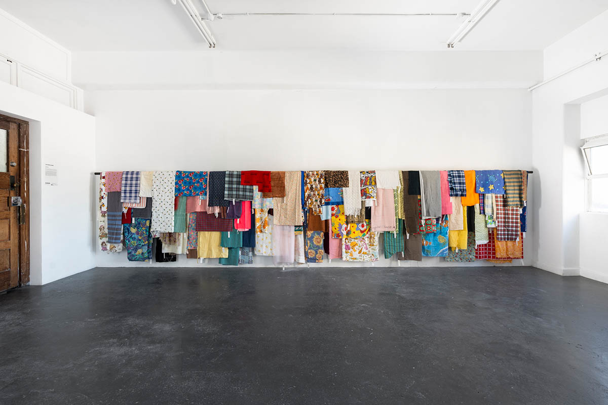 Amelia Skelton, Everything is sacred, 2024. Fabrics from the artist's collection, paper, pencil, ink, sticky tape, plastic tags, stained hardwood. Dimensions variable. Installation view, Blindside ARI, Melbourne. Photo: Astrid Mulder