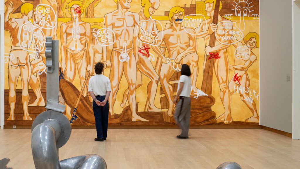Lucy McKenzie, If It Moves, Kiss It, 2002 (wandschildering). Collectie Stedelijk Museum Amsterdam, donatie Thomas Borgmann 2016. Eduardo Paolozzi, Neo-Saxeiraz, 1966 (sculptuur). Collectie Stedelijk Museum Amsterdam. In Beyond the Manosphere — Masculinities Today, 2026. Stedelijk Museum Amsterdam. Foto: Peter Tijhuis