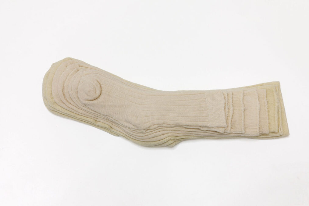 Stéphanie Saadé, Pyramide (chaussettes), 2022, Calzini di tutte le taglie esistenti (0-1 mesi al numero 42), filo / socks of all existing sizes (from birth to size 42), thread. Edizione 4/4 +1 AP, 28 x 9 cm. Ph: Danilo Donzelli. Courtesy of the artist and Galleria Tiziana Di Caro