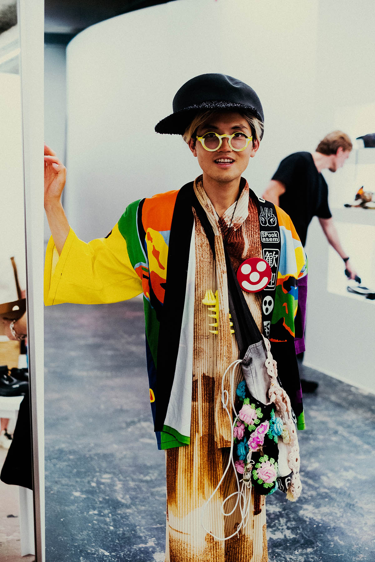 Lawson Wang - Portrait in a multicoloured jacket and sculptural black cap. Photo: Lies Oom