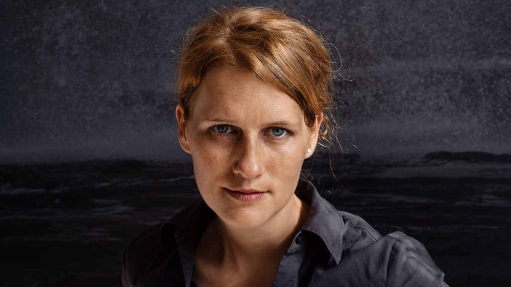 Portrait von Karen Irmer vor eigener Fotografie