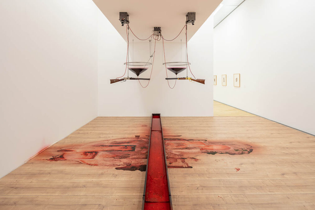 Rebecca Horn High Moon, 1991 2 air rifles (model: Winchester 1894), rifle mounts, 2 acrylic glass trays, saw with mount, metal trough, hoses, red, blood-like liquid, motor, pump, amplifier, switch box, electronics Installation dimensions variable Kunstmuseum Wolfsburg © VG Bild-Kunst, Bonn 2026 Photo: Marek Kruszewski