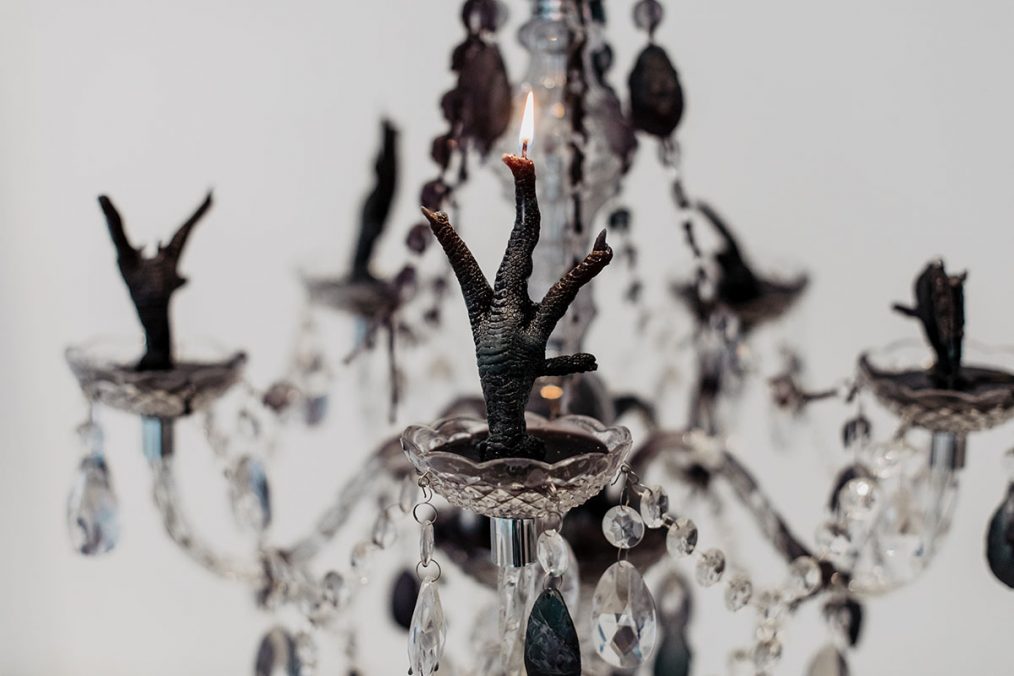 “The Séance”, 2021 (sculpture, multiple dimensions: acrylic & brass chandeliers, cast iron pulleys,10mm polypropylene braided rope, black paraffin wax) © Jolly Schwarz.